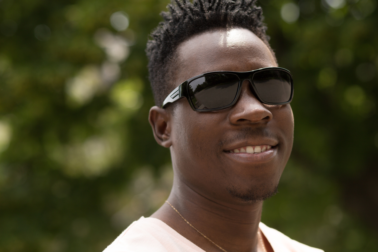 A person wearing sunglasses and smiling, Polarized Sunglasses and Your Summer Eye Protection Guide