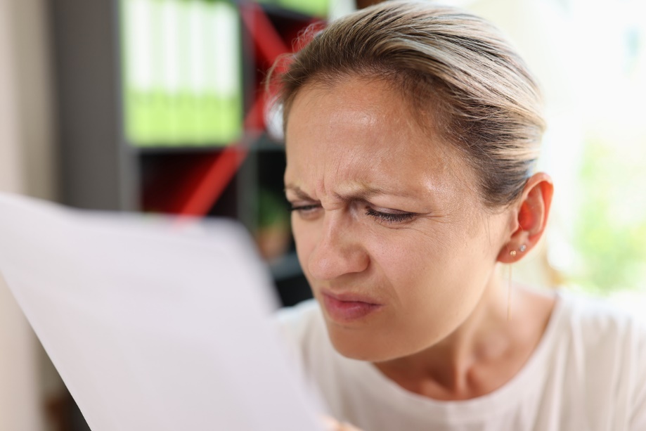 A person squinting at a piece of paper
