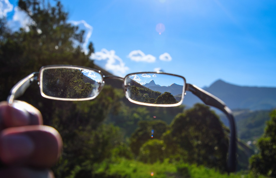 A pair of glasses with a view of a mountain range in the background