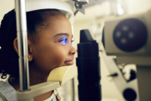 Annual Eye Exams for Children in Alice, Texas, Girl kid, face and eye exam with vision and laser machine, health and vision with optometry and wellness at clinic. Patient, LED light and scan retina for assessment with prescription and technology
