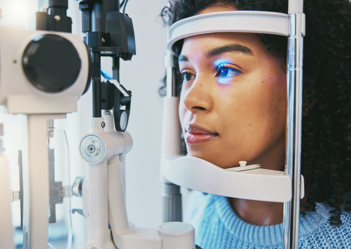 Close-up of a woman's eye undergoing an eye examination with a slit lamp.