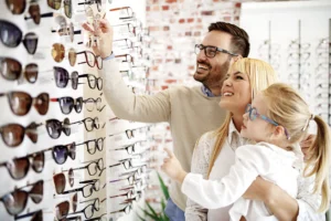 Family choosing eyeglass frames together at an optical store while shopping for new eyewear.