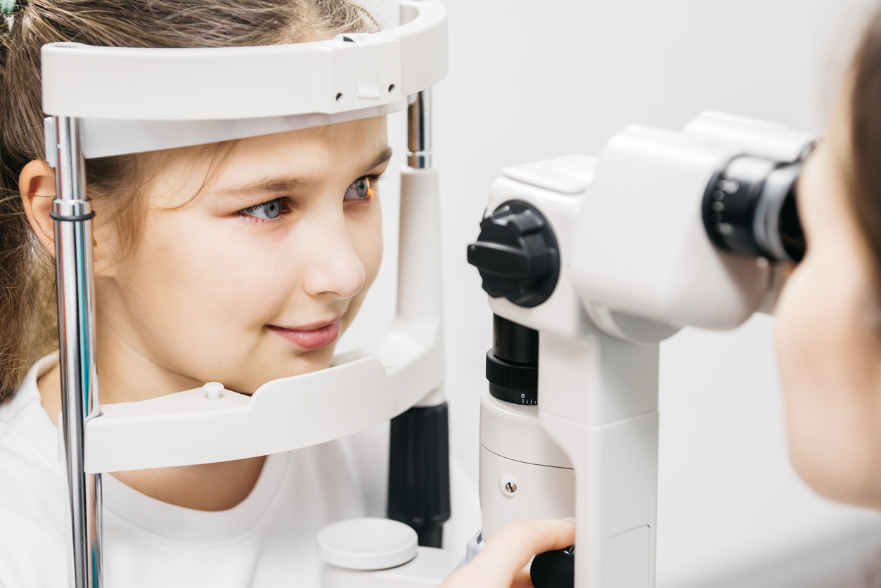 Child receiving a pediatric eye exam using specialized equipment to check her vision.
