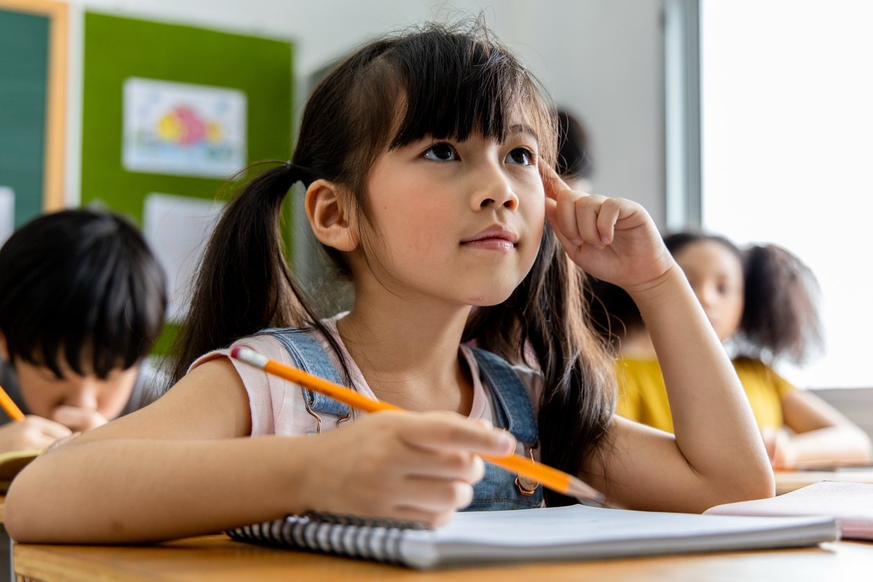 School-aged child looking toward the front of the classroom, highlighting the importance of pediatric eye exams for children.