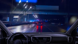 View from inside a car while driving at night on a highway.