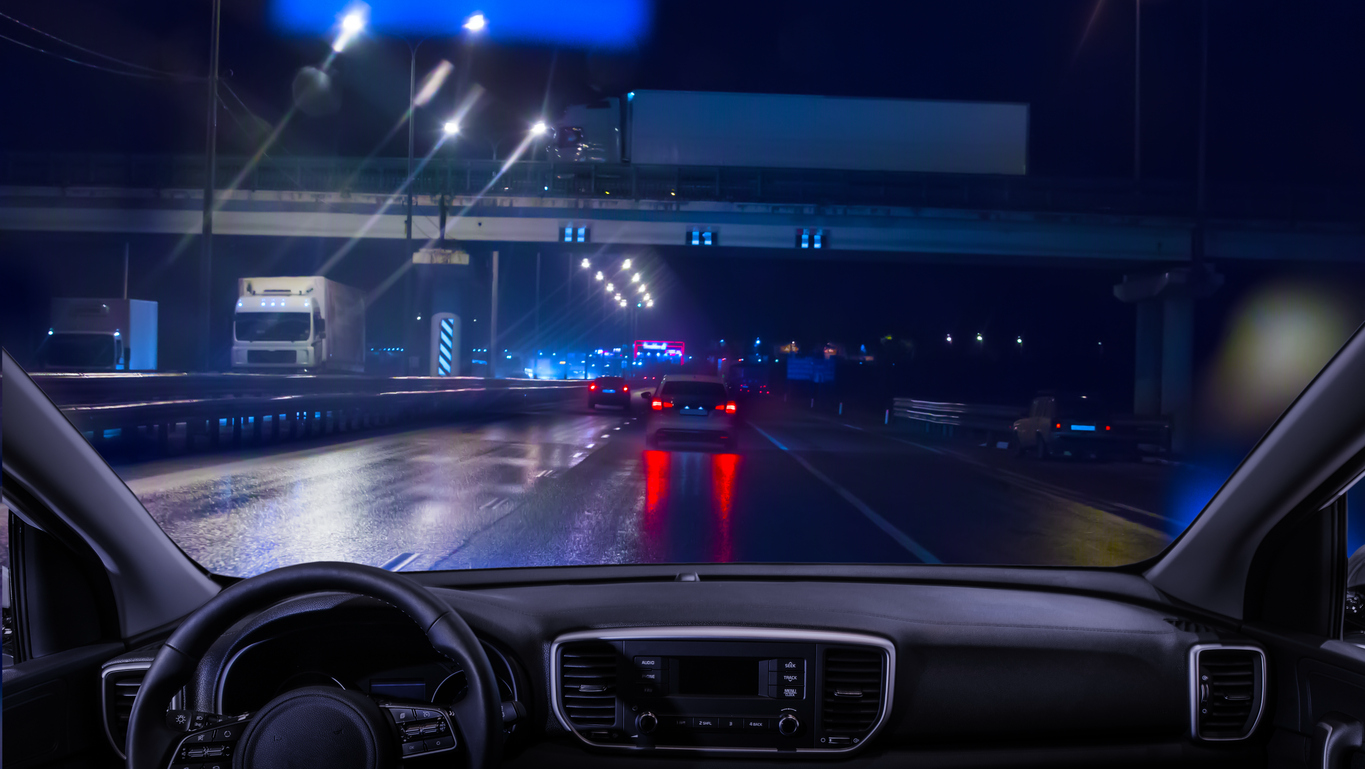 View from inside a car while driving at night on a highway.