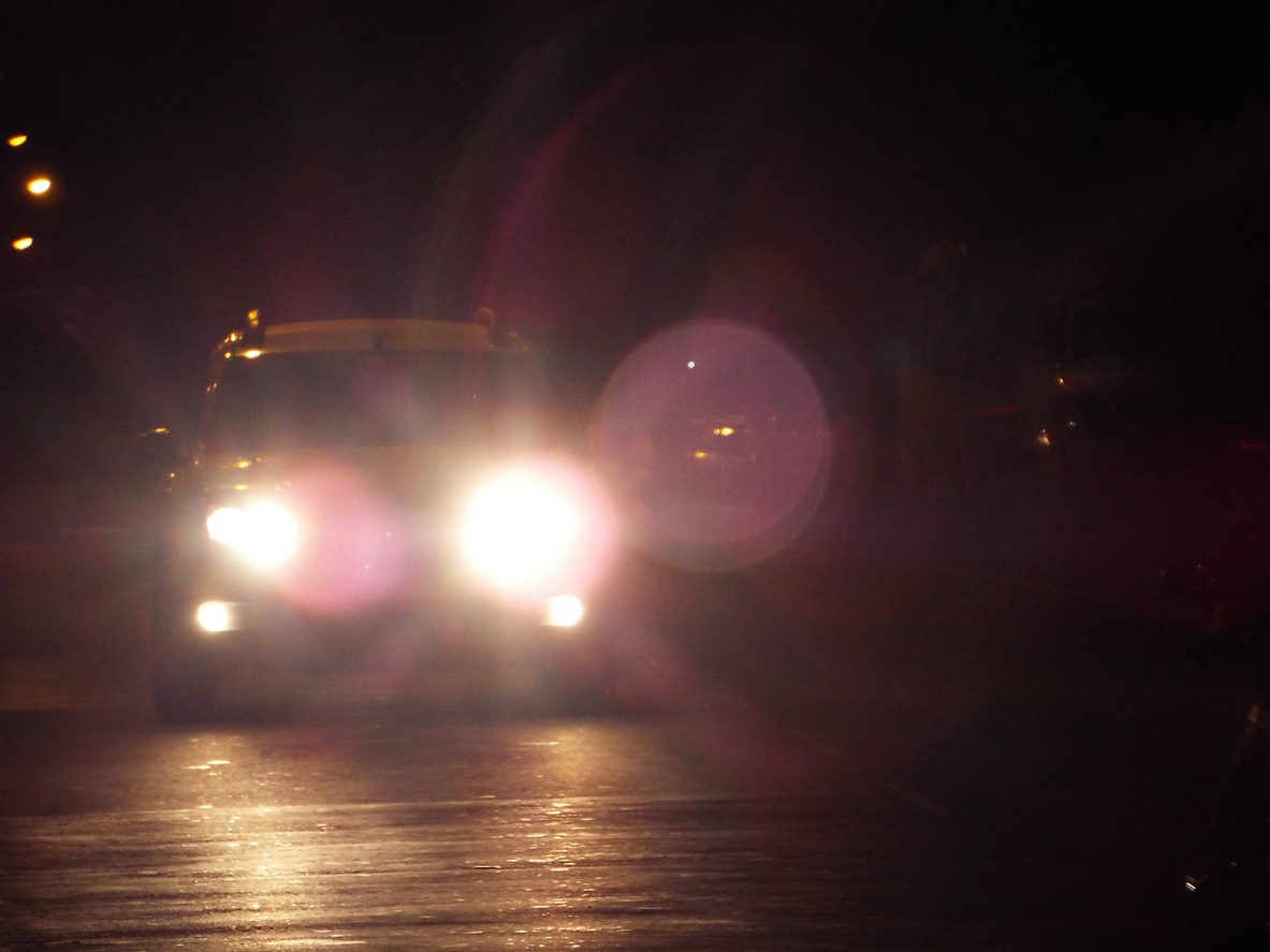 Bright oncoming headlights creating glare while driving at night.